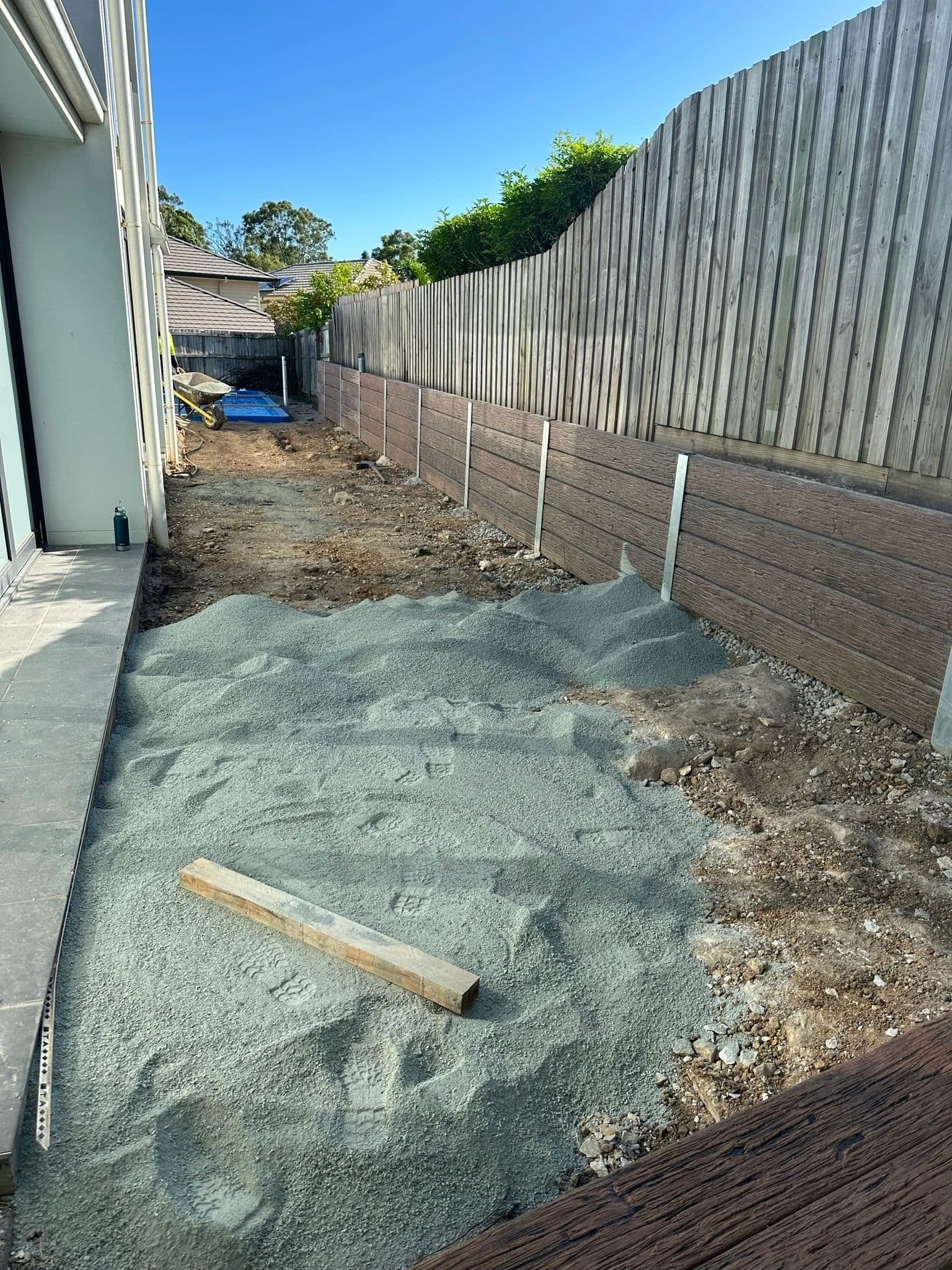 Side yard prepared with a compacted sand base ready for turf