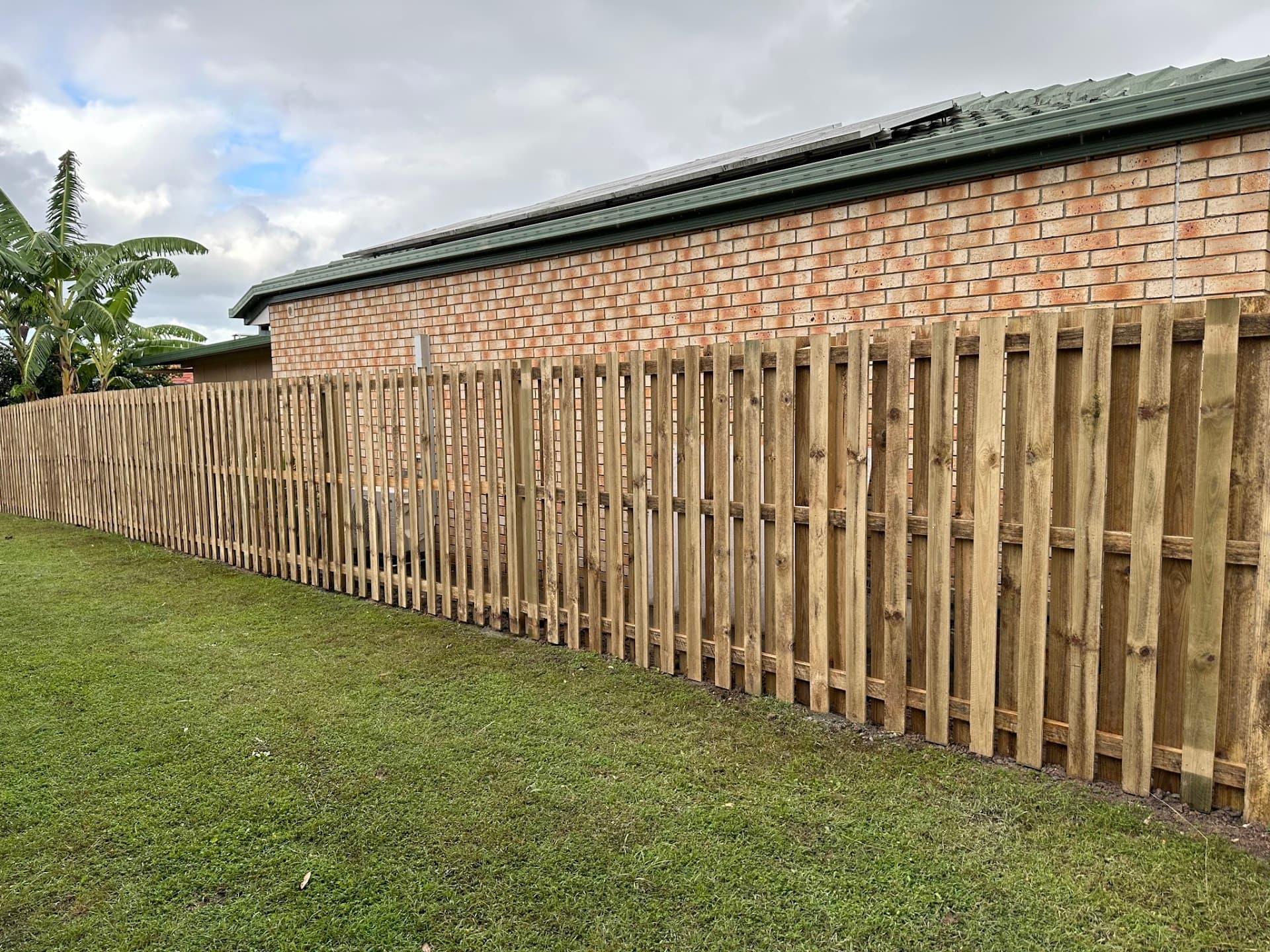 New lapped timber paling fence along a brick home on Brisbane's northside